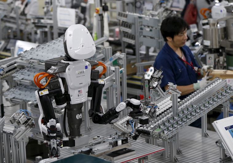 In una fabbrica, un robot umanoide lavora fianco a fianco dei dipendenti alla catena di montaggio. (Photo credit: REUTERS) 