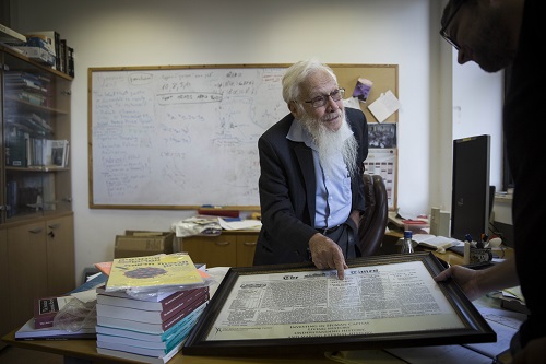 Professor Robert Aumann, shows a framed article from the London Times from 1917 in which the Balfour Declaration on Palestine for the Jews was published, at his office at the Givat Ram campus of the Hebrew University in Jerusalem, August 6, 2014. Aumann recieved the 2005 Nobel Prize in Economics. Photo by Hadas Parush/Flash90 *** Local Caption *** øåáøè éùøàì àåîï ôøñ ðåáì ëìëìä îúîèé÷àé úåøú äîùç÷éí ôøåôñåø øöéåðìéæéä
